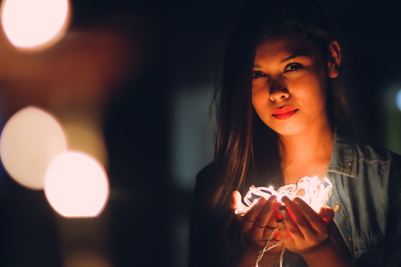 focus on foreground, young women, lip, holding, bokeh, women, young adult, celebration, headshot, front view, fairy lights, smile, warm light, christmas present