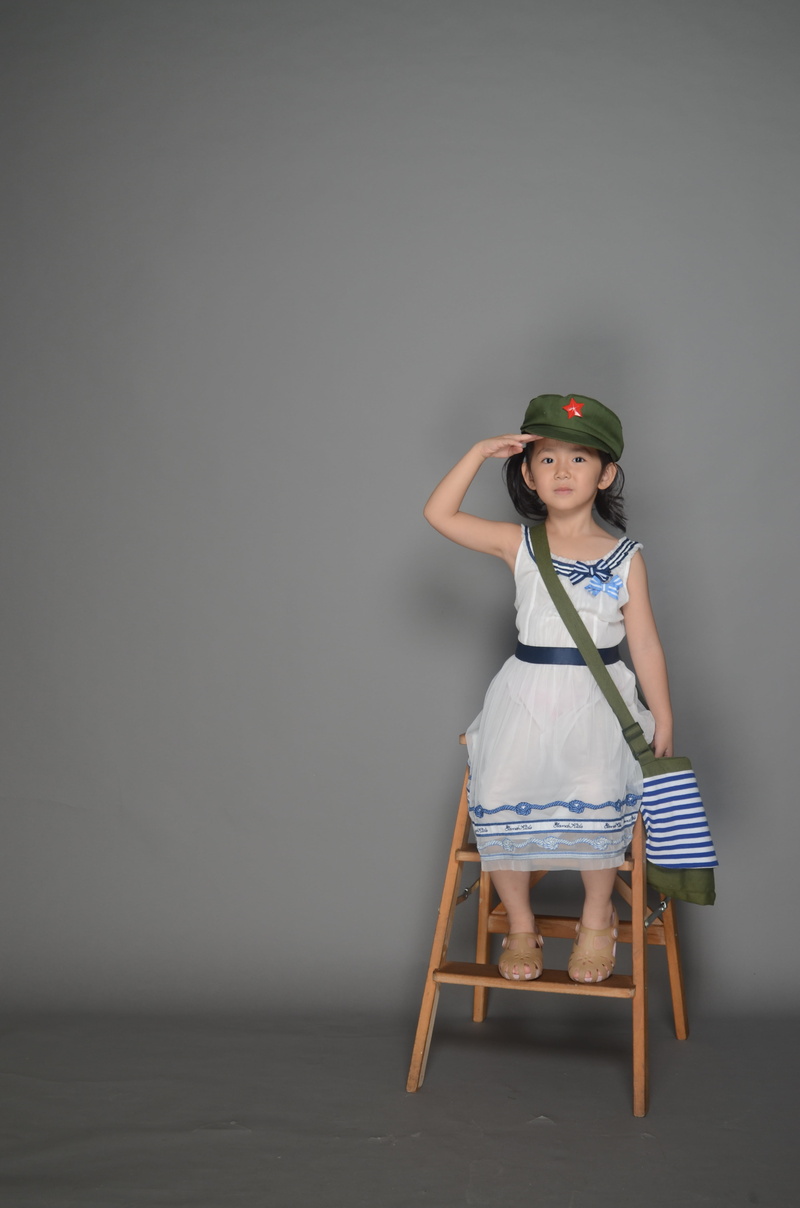 front view, studio Shot, army backpack, females, child, caucasian Ethnicity, innocence, leisure activity, hat, 4K, real people, sitting, studio, casual clothing