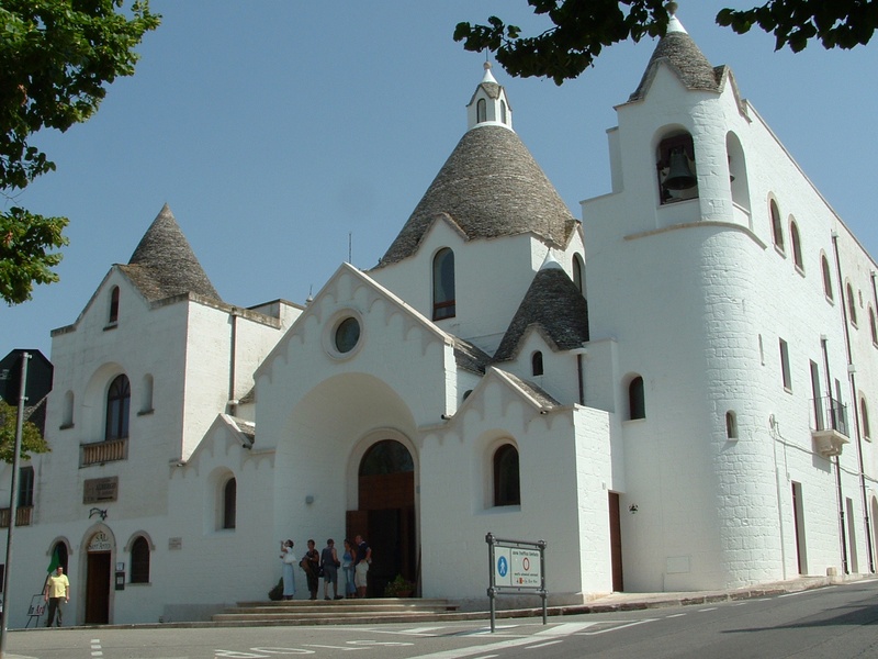 architecture, sky, alberobello, trulli, day, sunlight, church, place of worship, incidental people, spire, building exterior, tower, built structure, city