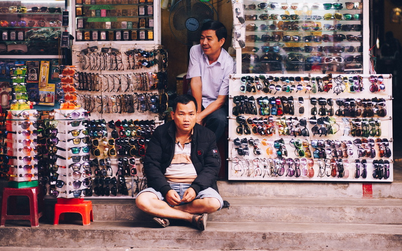 front, glasses, apparel, footwear, retail, shelf, clothing, asia, full length, shoe shop, shop, bazaar, person, two people, second, adult, shoe, market