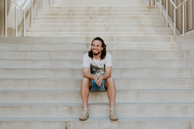 tee, steps and Staircases, smiling, beautiful woman, lifestyles, built Structure, sit, physical Position, concrete, portrait, front view, human Age, women