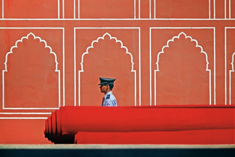 government, wall - building feature, man, building exterior, clothing, hat, red, one person, 2K, india, palace, sitting, occupation, carpet, wall, architecture