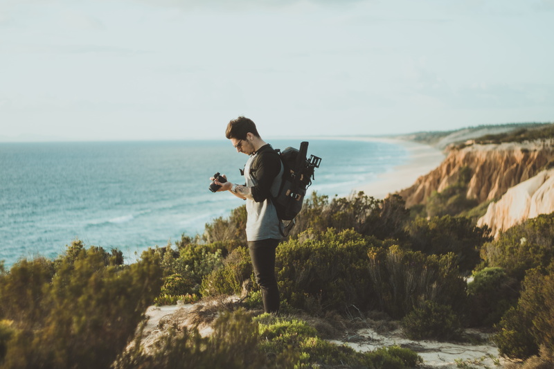 photography, young adult, portugal beach, lifestyles, 5K, backpack, top view, outdoors, looking at the camera, camera, man, backpacker, rock, beach, summer
