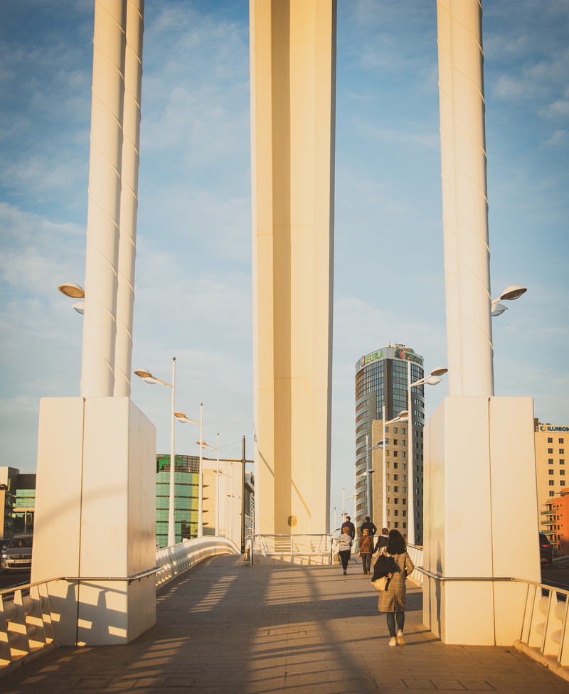 skyscraper, tall - high, nature, banister, walkway, people, built structure, railing, buildings, sky, handrail, pavement, town, city, day, pedestrian, city life