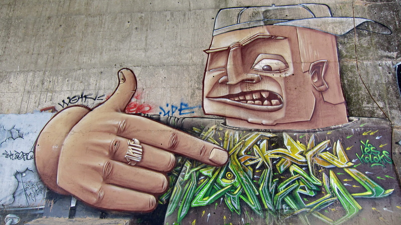 man, wall - building feature, finger, body part, wood - material, one person, Art, day, caricature, outside, carving - craft product, outdoors, real people