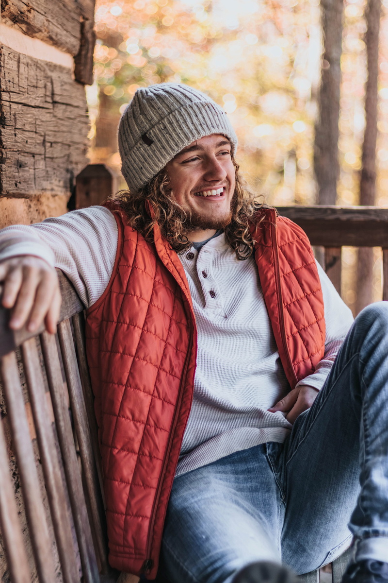 person, fall, smiling, apparel, denim, chair, young adult, furniture, one person, cap, sweater, sitting, clothing, hat, happiness, 5K, wood, lifestyles