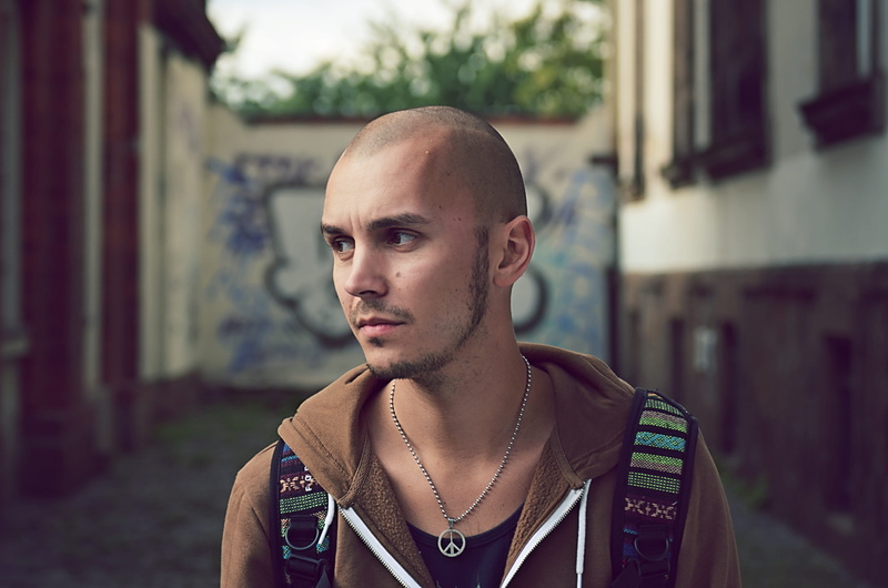 front view, headshot, casual clothing, necklace, model, color, brown, colorful, person, shaved head, wearing, adult, calm down, pose, hairstyle, bokeh