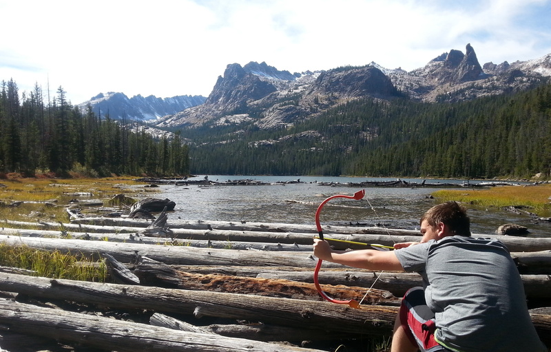 outdoors, rear view, leisure activity, lifestyles, arrow, nature, lake, goofing around, one person, non-urban scene, mountain, day, cloud - sky, boy, mountain range