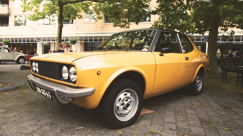 land vehicle, retro styled, transportation, day, hood, trees, road, vintage car, incidental people, motor vehicle, mode of transportation, building exterior