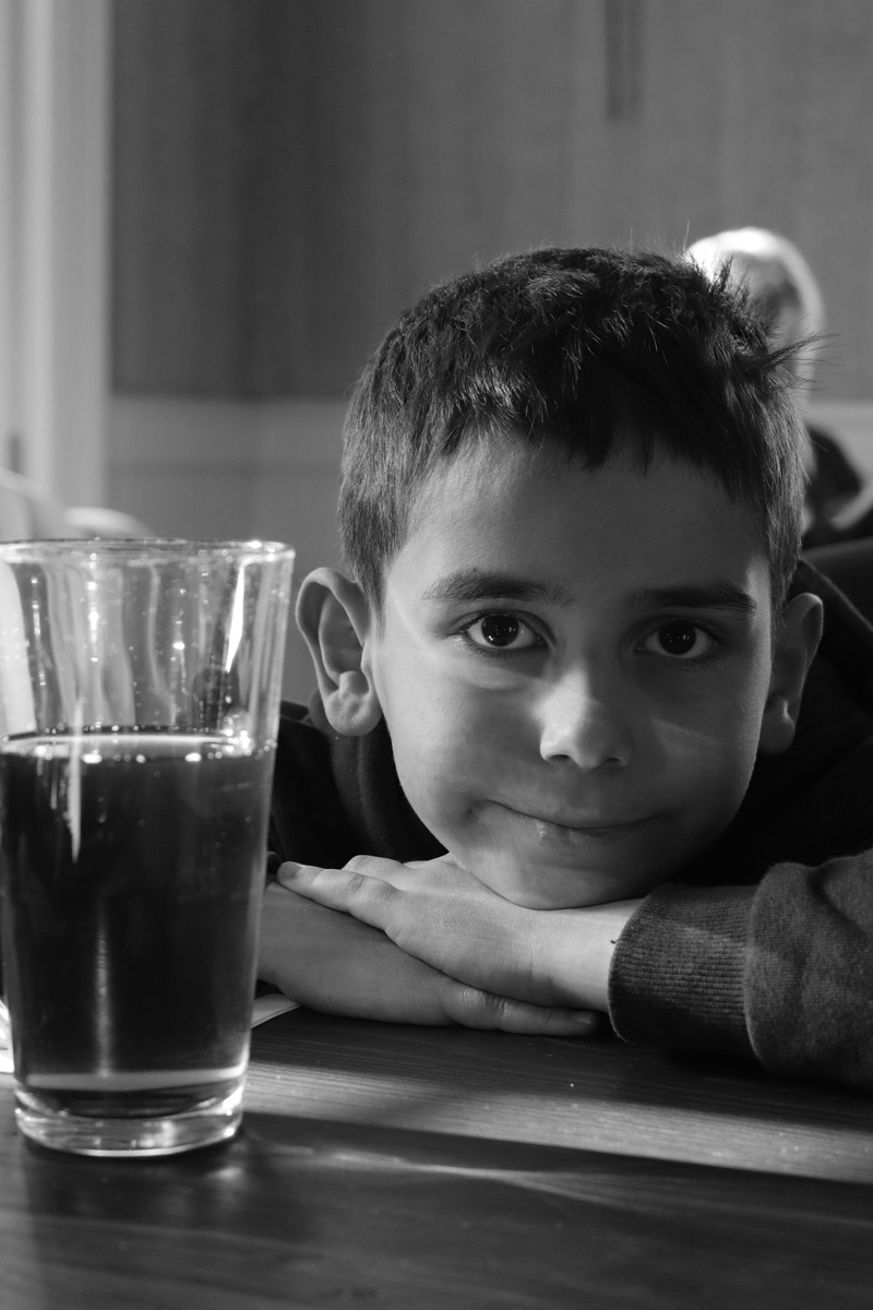 human face, focus on foreground, real people, looking at camera, black and white, headshot, smile, food and drink, istanbul, glass, turkey, boys, one person