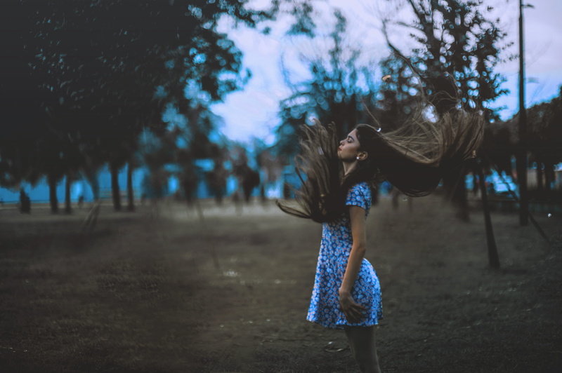 dusk, dress, women, hair toss, near, plant, hairstyle, wind, fashion, windy, girl, clothing, dark, outdoor, outside, one person, standing, brown, outdoors