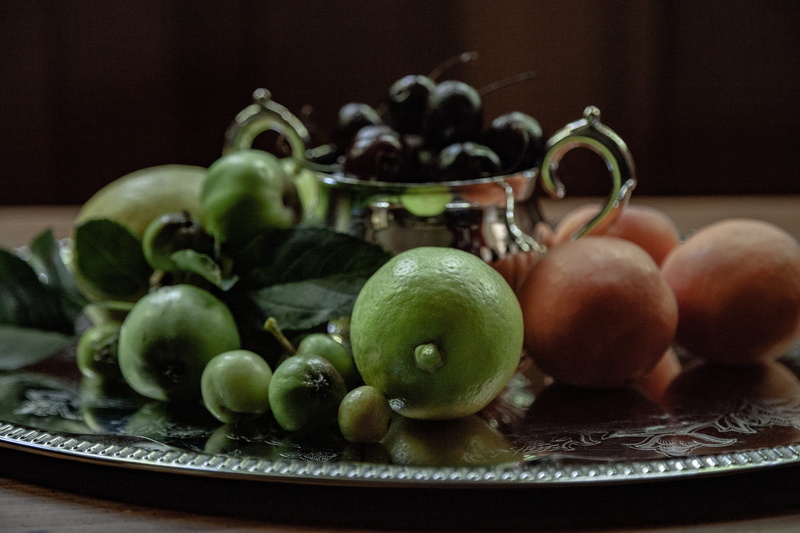 selective focus, blue mountains, cherry, engraved, large group of objects, household equipment, fruit and flower, 4K, close-up, old world, reflection