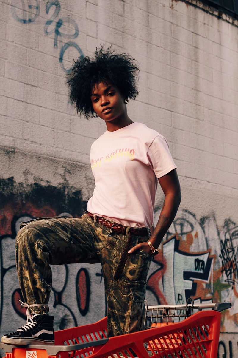 graffiti, three quarter length, smiling, female, casual clothing, outdoors, woman, day, shopping, standing, hi, built structure, portrait, lifestyles, red