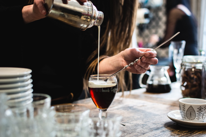 food and drink, holding, cup, table, coffee, coffee - drink, one person, refreshment, drink, preparation, pouring, irish coffee, bar counter, human body part