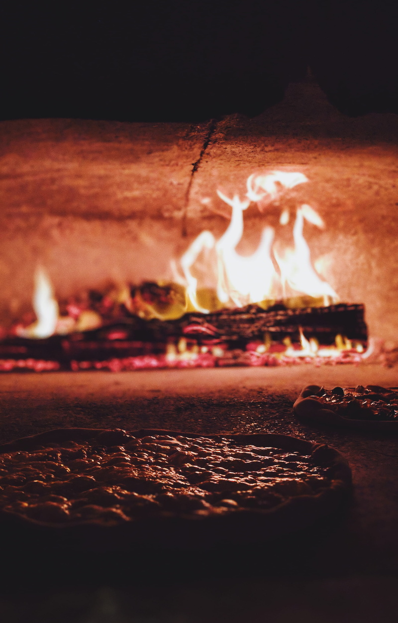 glowing, food and drink, cooking, selective focus, india, fire, oven, goblet, interior design, fireplace, food, event, pizza, runway, flame, night, illuminated