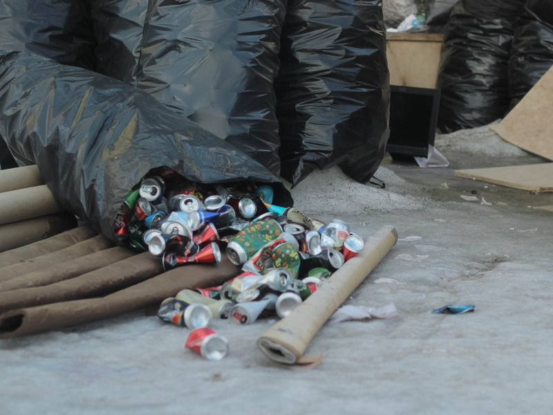 poured, people, clothing, textile, symbol, large group of objects, plastic, human leg, skateboard, helmet, shoe, stack, apparel, arrow, body part, indoors