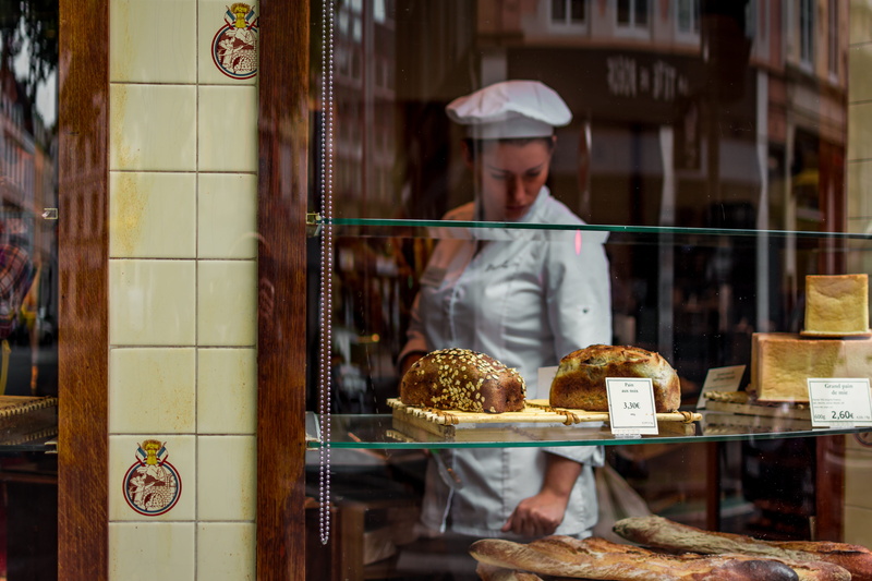 baked, person, display cabinet, city, indoors, glass, baker, food and drink, occupation, consumerism, business, sell, woman, bakery, small business, store