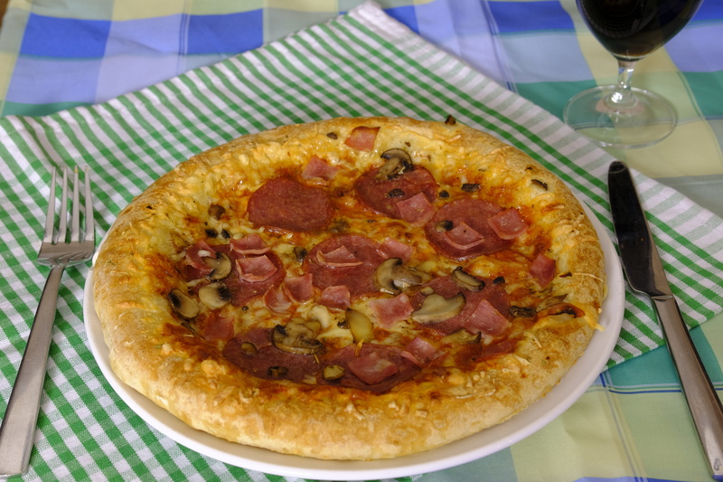 sausage, alcohol, baked, no people, cheese, table knife, topping, restaurant, ham, meal, place mat, glass, fork, pizza, table, mushrooms, high angle view
