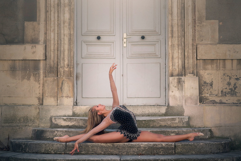 human arm, one person, shirt, clothing, day, sitting, architecture, beautiful woman, real people, entrance, Océane Charoy, gymnast, leisure activity, arms raised