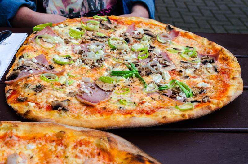 indoors, cheese, plate, round, restaurant, meal, food and drink, delicious, pizza topping, pizzeria, fast food, food, mushroom, human hand, pizza, vegetable pizza