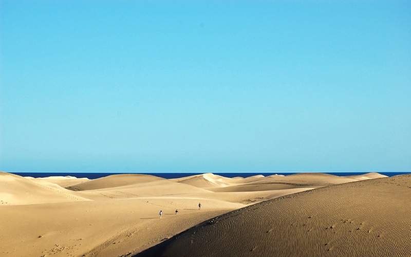 sand, non-urban scene, beauty in nature, no people, tourism, arid climate, travel, clear sky, outdoors, beach, copy space, horizon over water, day, climate