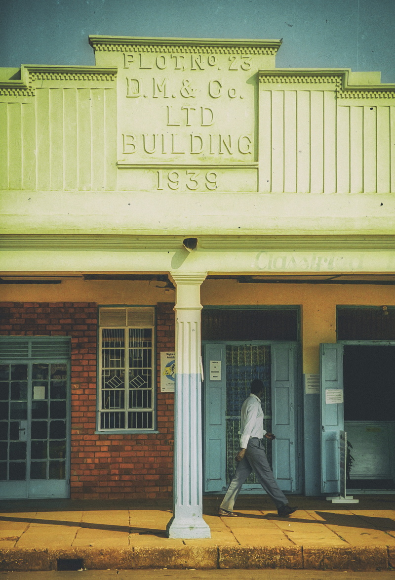 architectural column, communication, uganda, brick, outdoors, city, lifestyles, rear view, door, full length, text, pants, jinja, building exterior, flot