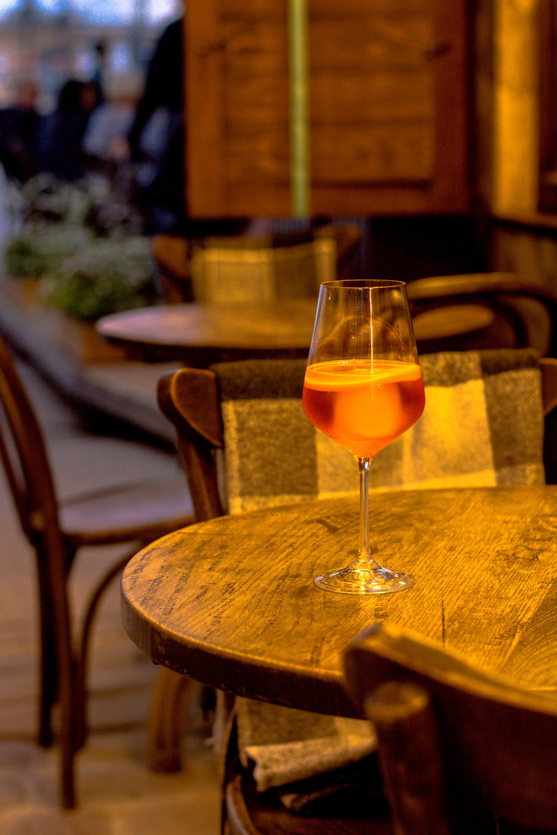 person, cocktail, focus on foreground, wood, setting, seat, indoors, wineglass, chair, refreshment, red wine, wine glass, business, glass, food and drink