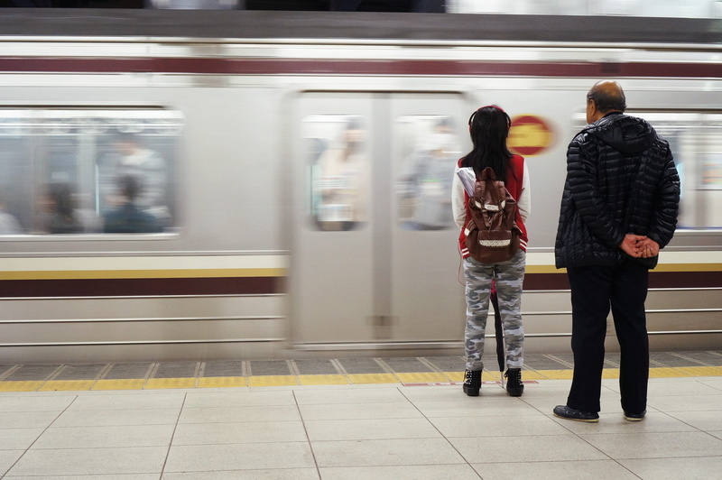 subway train, public transportation, outdoors, two people, adult, motion, rail transportation, mode of transportation, casual clothing, railroad station