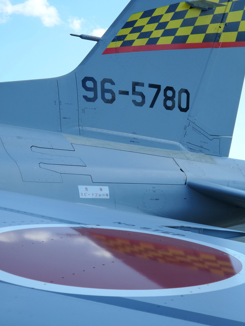 fighter, transportation, day, close-up, hamamatsu, western script, outdoors, mode of transportation, metal, airshow, tail, nature, air, text, army, show