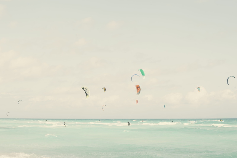 beach, scenics - nature, beauty in nature, surf, vacations, paragliding, water, cloud - sky, extreme sports, kite, group, holiday, land, surfers, horizon