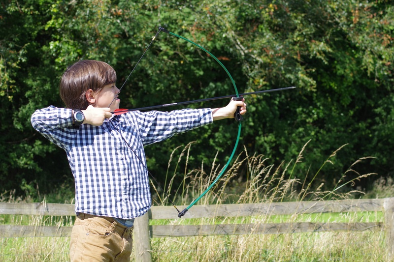 blue, outdoors, bowman, males, kid, playing, three quarter length, child, crossbow, weapon, plant, standing, nature, checked, summer, young, leisure activity