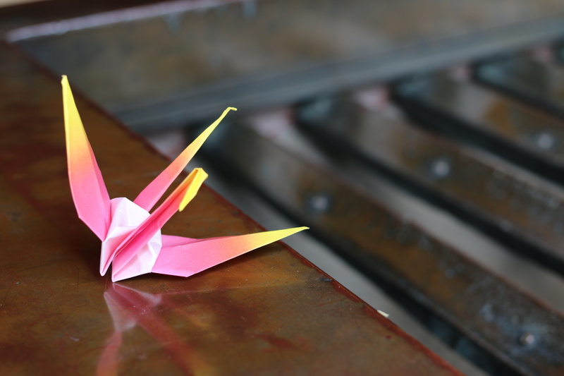creativity, indoors, animal representation, offertory box, crane, still life, paper, table, close-up, pink color, day, paper boat, toy, focus on foreground