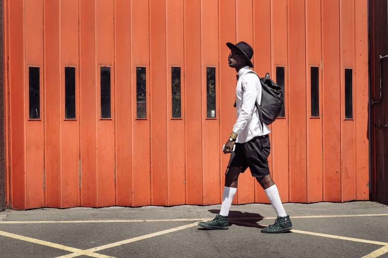 childhood, gate, hat, full length, child, standing, dress, real people, black, white, wearing, wall - building feature, males, walking, day, clothing, one person