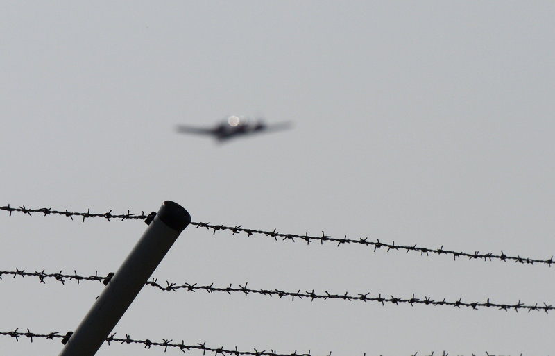 low angle view, restricted zone, nature, barbed wire, communication, twin engine, outdoors, day, propeller plane, safety, technology, airport, departure