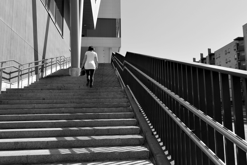 architecture, lifestyles, rear view, city, sky, water, day, building exterior, adult, grayscale, banister, built structure, 5K, outdoors, path, apparel