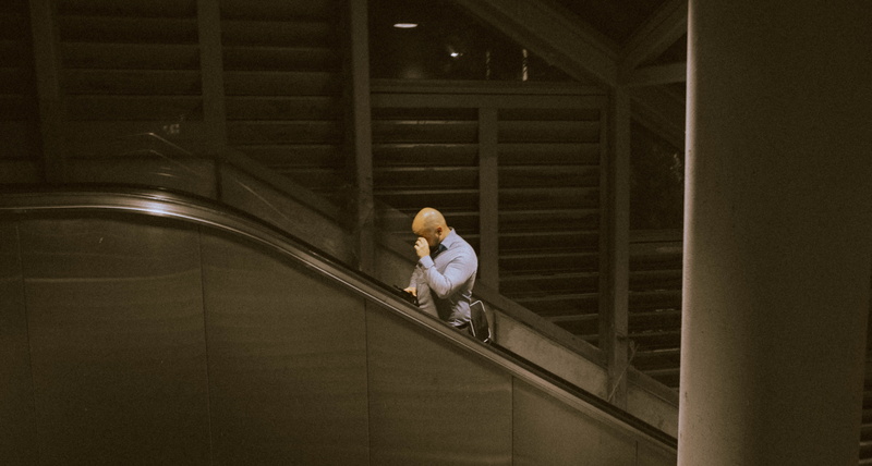 person, young adult, home decor, reflection, monitor, sitting, lcd screen, staircase, riding, window, building, adult, pants, leisure activity, human, banister