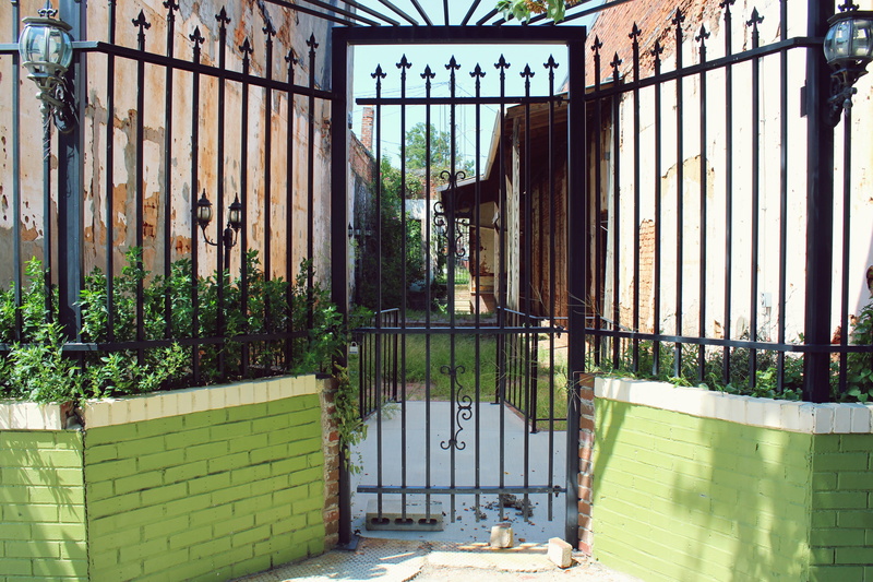built structure, alleyway, plant, iron work, building exterior, wrought iron, wall, brickwork, no people, black, nature, deterioration, green color, building