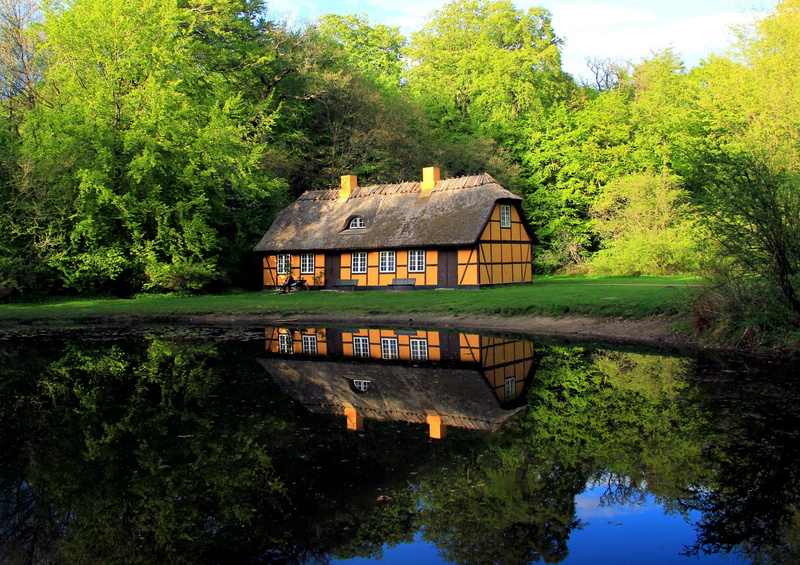 tranquil scene, building exterior, reflection, lake, tree, house, water, near, trees, plant, Denmark, day, built structure, brown, pond, nature, comfort