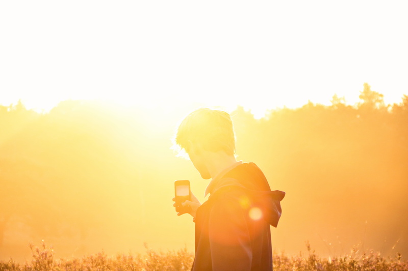 grass, young Adult, sunlight, outdoor, looking, nature, happiness, lifestyles, caucasian Ethnicity, smartphone, standing, sunrise - Dawn, technology, sunset