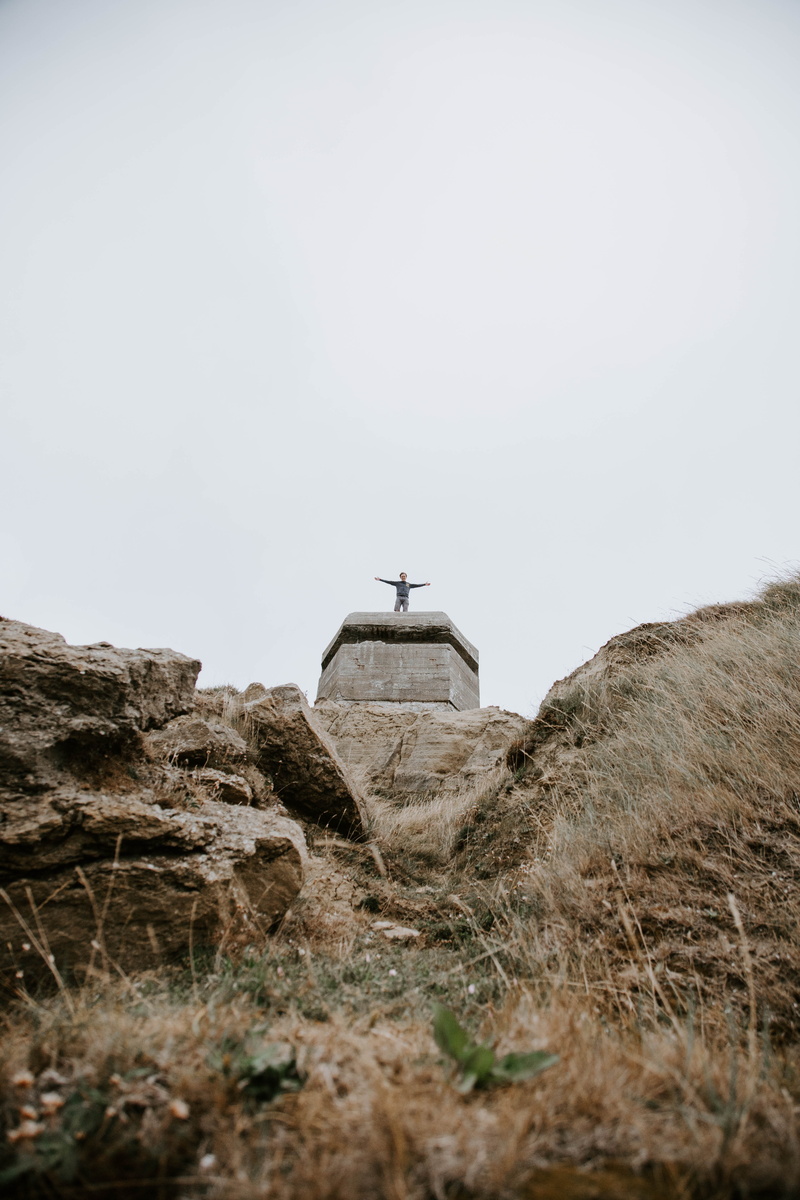 arms outstretched, low, famous Place, landscape, mountain, church, angle, open arms, tower, stone Material, outdoors, statue, grass, scenics