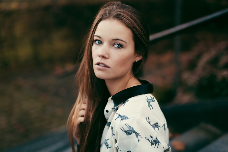 looking at camera, contemplation, long hair, hair, depth of field, brunette, casual clothing, focus on foreground, young adult, looking at viewer, women