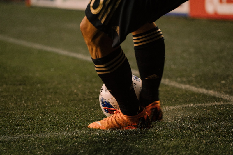 football boots, sport, grass, low section, human leg, 5K, day, black, cleats, shoe, soccer field, lawn, team sport, focus on foreground, sports equipment