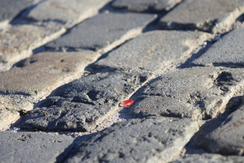 surface level, red glass, city, cobblestone, adoquines, day, outdoors, road, cracked, cristal rojo, close-up, solid, shadow, land, cobble, selective focus