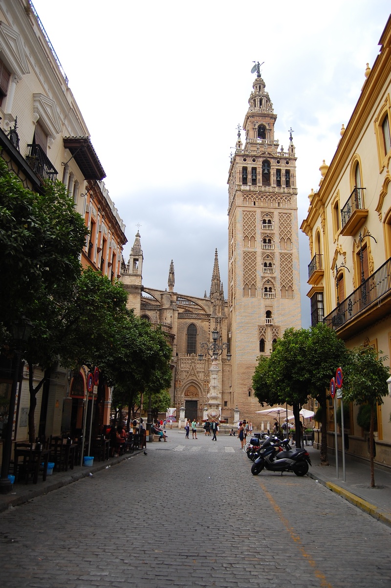 sky, seville, brown, nature, place of worship, group of people, outdoors, mode of transportation, backlight, people, car, transportation, palms, religion
