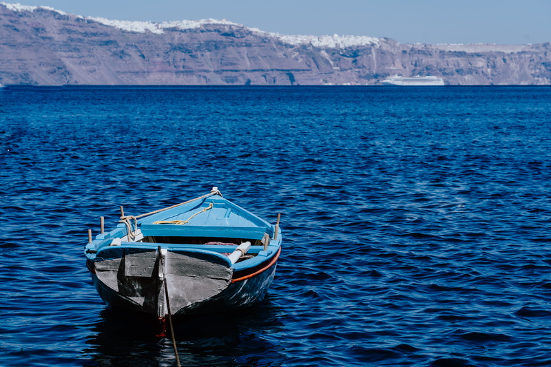 non-urban scene, no people, tranquility, boat, moored, oia, water, waterfront, outdoors, beauty in nature, blue, transportation, mountain, mountain range
