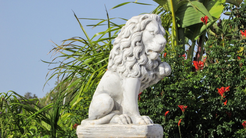 human representation, no people, lion, green color, stone material, guardian, day, representation, 4K, park - man made space, plant, outdoors, statue