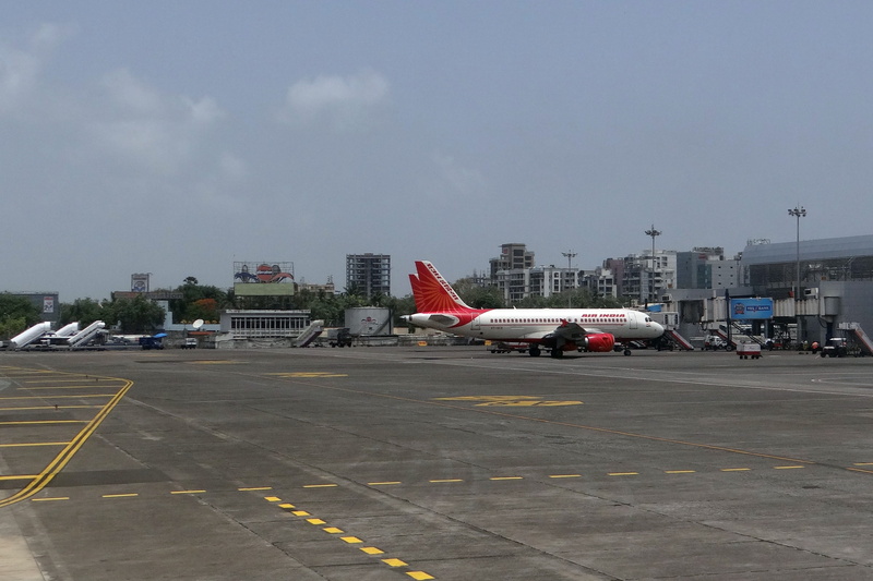 Air India, Airport, street, airport runway, transportation, road, outdoors, symbol, no people, building exterior, land vehicle, motor vehicle, city, sky