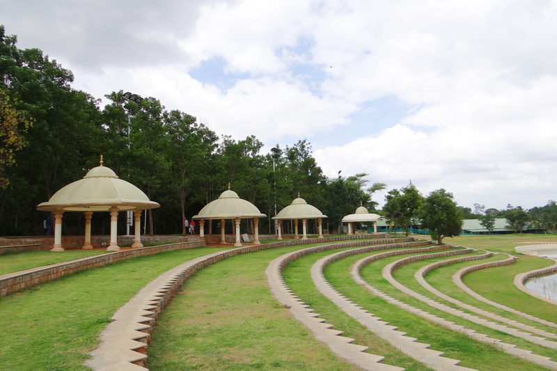 tree, built structure, landscape, open air theatre, growth, building, india, karnataka, building exterior, cloud - sky, art of living, no people, land