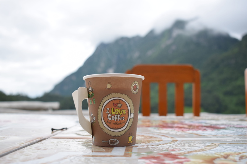Mountains, outdoors, snow, non-urban scene, focus on foreground, food and drink, Dao, table, cup, mountain, mountain range, close-up, drink, nature, absence