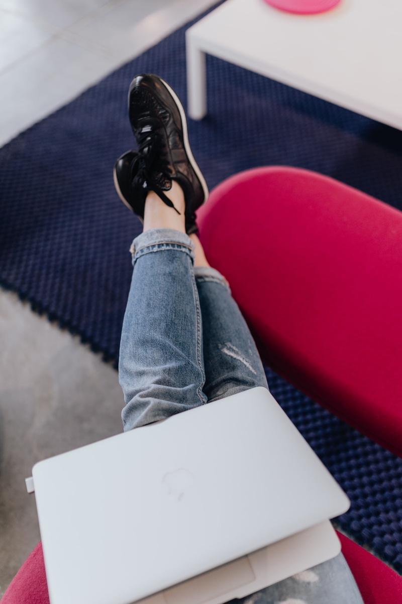 casual clothing, sofa, sneakers, shoes, red, pink, using, female, working, cross, legs, trousers, sport, full length, chair, jeans, blogger, women, blogging